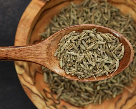 pexels-photo-10487762-10487762 Detailed image of cumin seeds on a wooden spoon for culinary use.