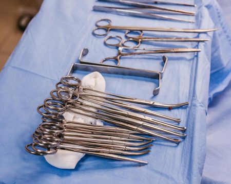 pexels-photo-28727574-28727574 Set of sterile surgical instruments on a blue drape in an operating room.