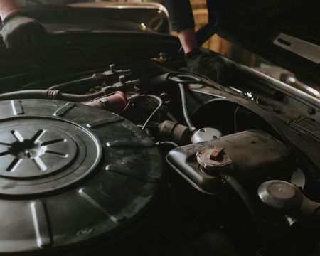 pexels-photo-4489765-4489765 Close-up of a mechanic repairing a car engine in a garage setting.