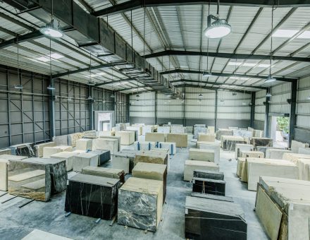 Expansive warehouse filled with large stone slabs for industrial use.